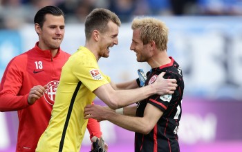 Eintracht-Torwart Lukas Hradecky jubelt nach Spielende mit Stefan Aigner und Heinz Lindner. 