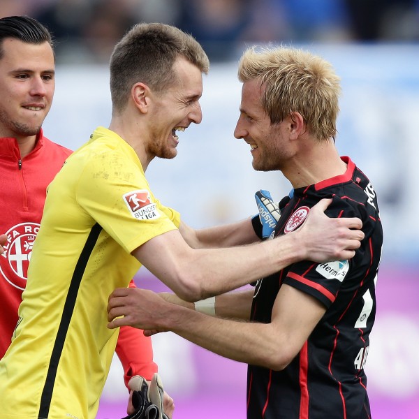 Eintracht-Torwart Lukas Hradecky jubelt nach Spielende mit Stefan Aigner und Heinz Lindner. 