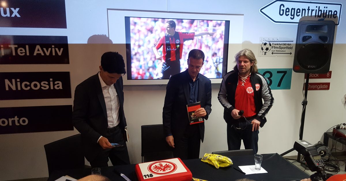 Bruno Hübner und Fredi Bobic schauen zusammen mit Moderator Axel „Beve“ Hoffmann auf den Geburtstagskuchen.